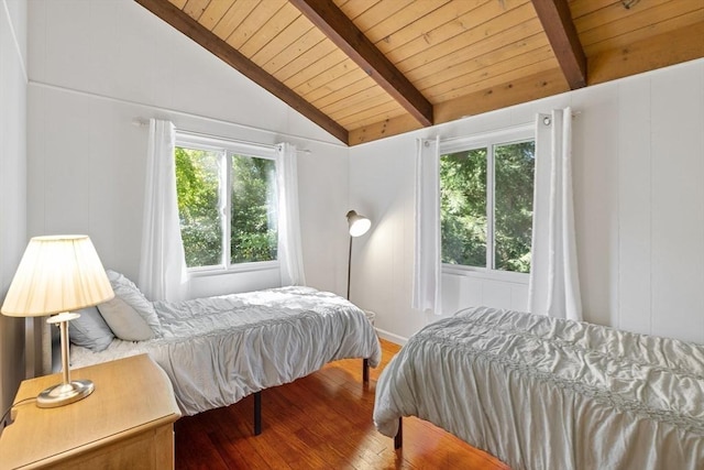 bedroom with wooden ceiling, a decorative wall, lofted ceiling with beams, and wood finished floors