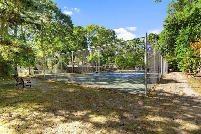 view of home's community with a tennis court and fence