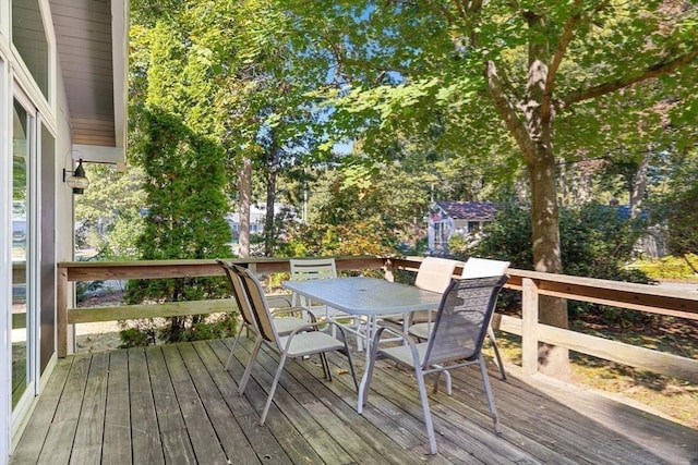 wooden terrace featuring an outdoor structure and outdoor dining space