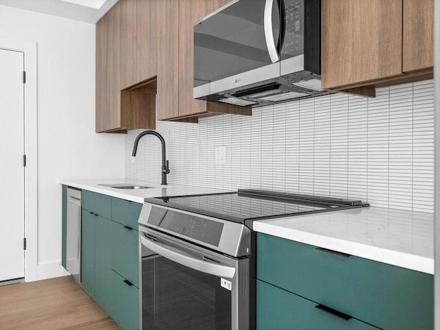 27 Dixwell Unit 1, Boston, MA 02119 - kitchen featuring appliances with stainless steel finishes, a sink, backsplash, light countertops, and light wood-style flooring