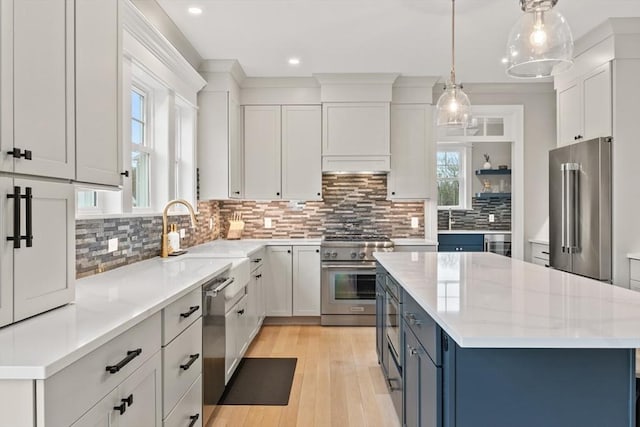 170 Lafayette Ave, Wrentham, MA 02093 - kitchen featuring high end appliances, decorative backsplash, blue cabinets, a kitchen island, and white cabinets