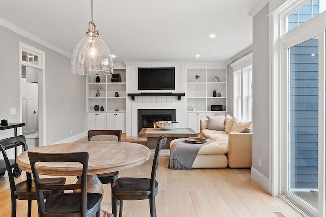 170 Lafayette Ave, Wrentham, MA 02093 - dining room featuring light wood-style flooring, a lit fireplace, ornamental molding, and recessed lighting