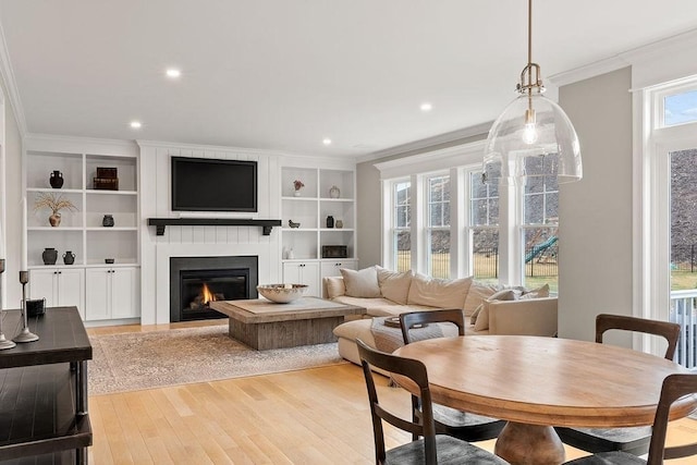 170 Lafayette Ave, Wrentham, MA 02093 - dining space with crown molding, light wood-type flooring, a fireplace, built in shelves, and recessed lighting