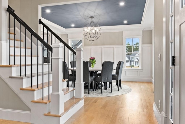 170 Lafayette Ave, Wrentham, MA 02093 - dining room featuring hardwood / wood-style flooring, ornamental molding, a chandelier, a decorative wall, and stairs