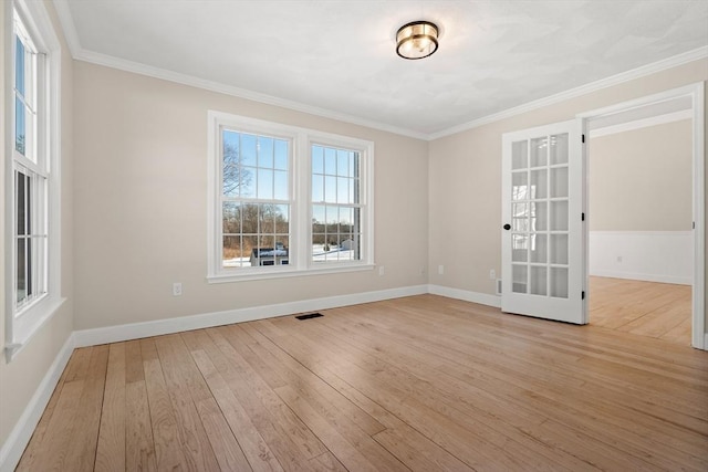 empty room featuring french doors, crown molding, and light hardwood / wood-style flooring