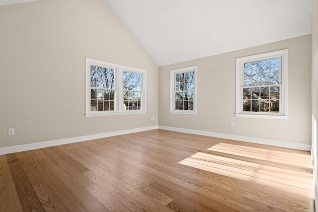 empty room with light hardwood / wood-style floors and vaulted ceiling