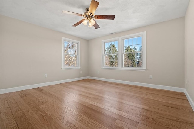 empty room with ceiling fan and light hardwood / wood-style flooring