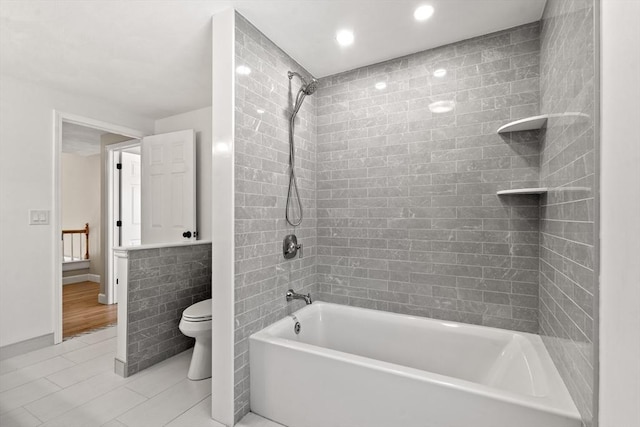 bathroom with tile patterned flooring, toilet, and tiled shower / bath