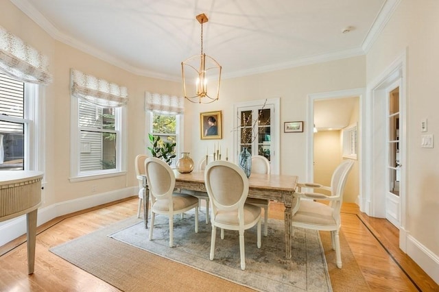 dining room featuring light hardwood / wood-style flooring, an inviting chandelier, and crown molding