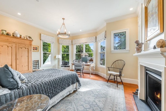 bedroom featuring hardwood / wood-style floors, an inviting chandelier, multiple windows, and ornamental molding