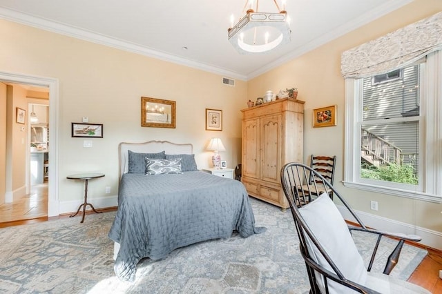 bedroom featuring light hardwood / wood-style floors, ornamental molding, and a notable chandelier