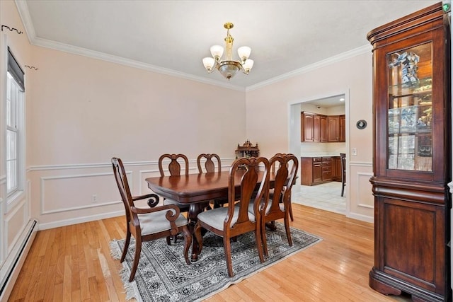 dining area featuring a notable chandelier, crown molding, light wood-type flooring, and baseboard heating