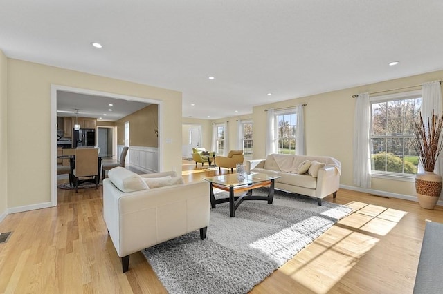 living room featuring visible vents, recessed lighting, and a wealth of natural light