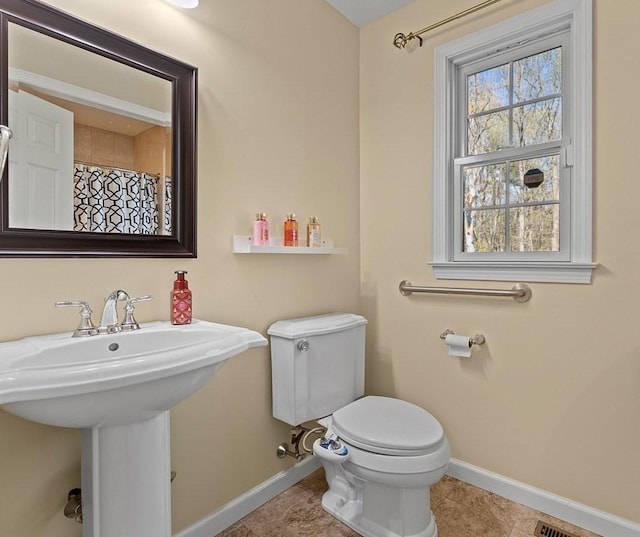 bathroom with toilet, baseboards, a sink, and tile patterned floors