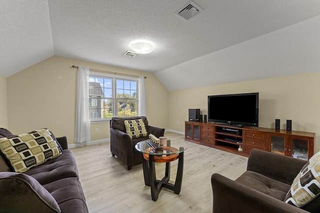 living room featuring light wood-style floors, lofted ceiling, and visible vents