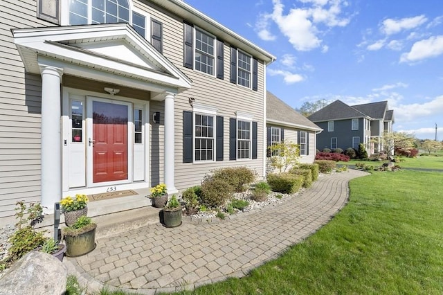 property entrance with a lawn