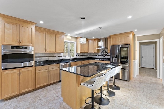 kitchen with wall chimney range hood, tasteful backsplash, dark stone counters, a breakfast bar, and stainless steel appliances