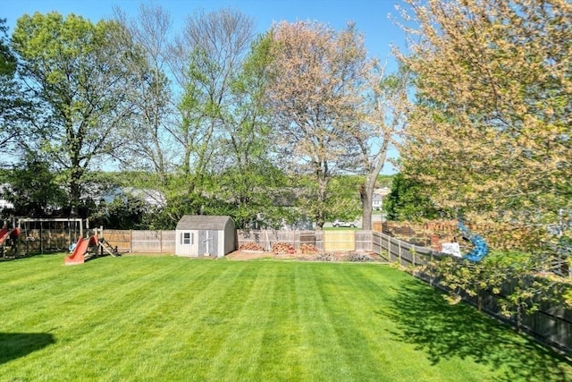 view of yard with a storage unit, a playground, and an outbuilding