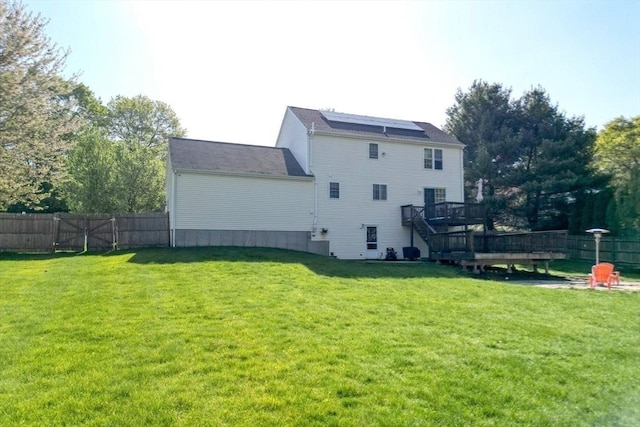 back of property with a deck, solar panels, and stairway