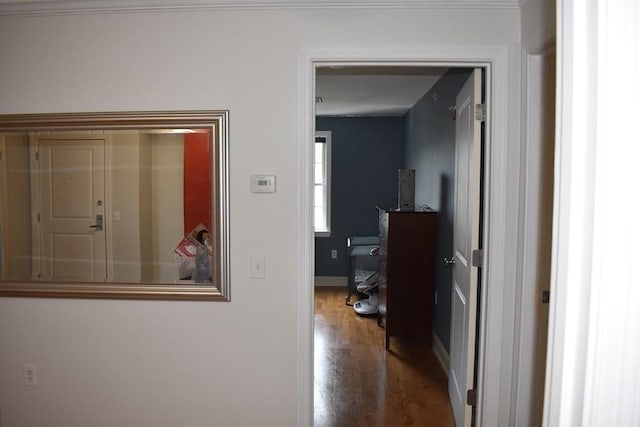 hall with baseboards and wood finished floors