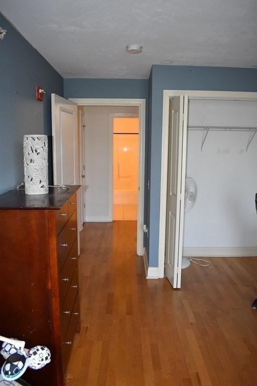 hallway with baseboards and wood finished floors