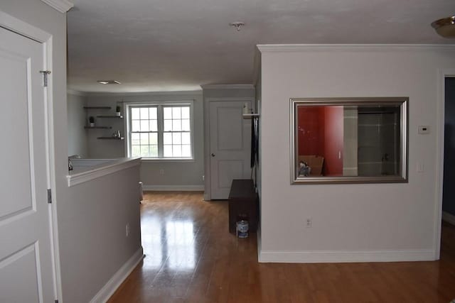 corridor featuring ornamental molding, wood finished floors, and baseboards