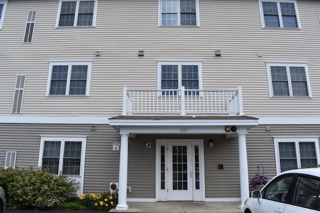 view of exterior entry with a balcony