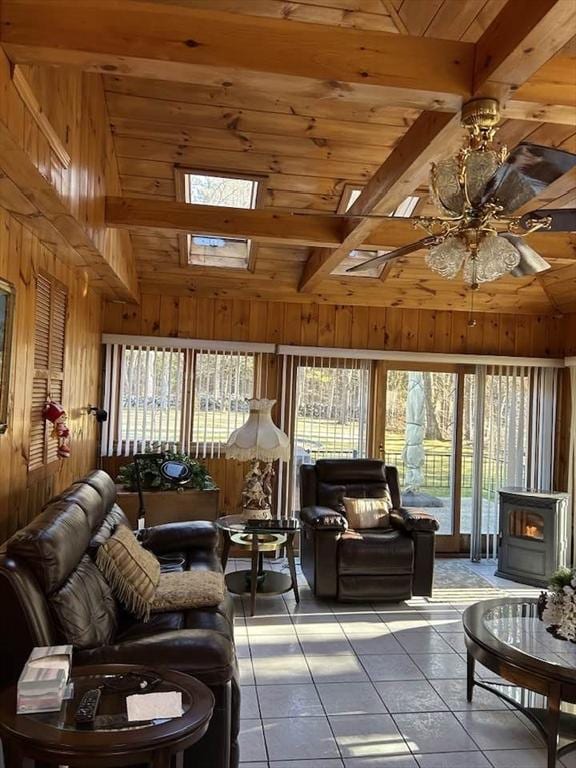 living room with beam ceiling, ceiling fan, wooden walls, and wood ceiling