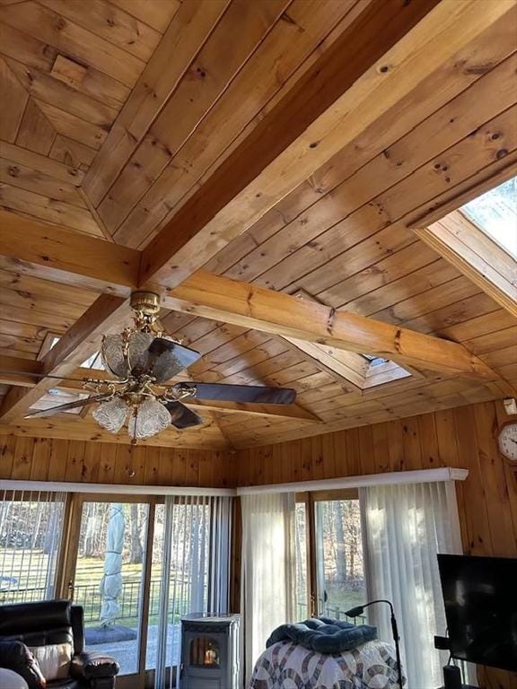 unfurnished bedroom featuring multiple windows, lofted ceiling with skylight, wooden ceiling, and wood walls