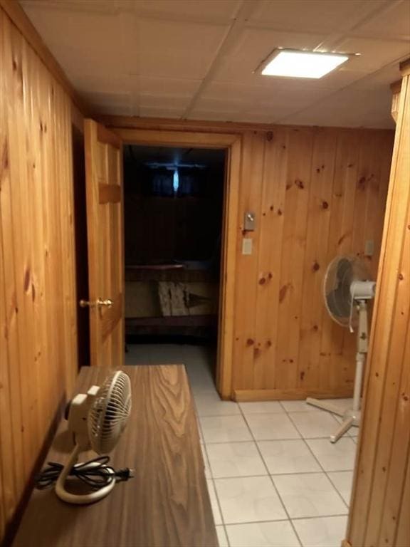 interior space with tile patterned floors and wooden walls