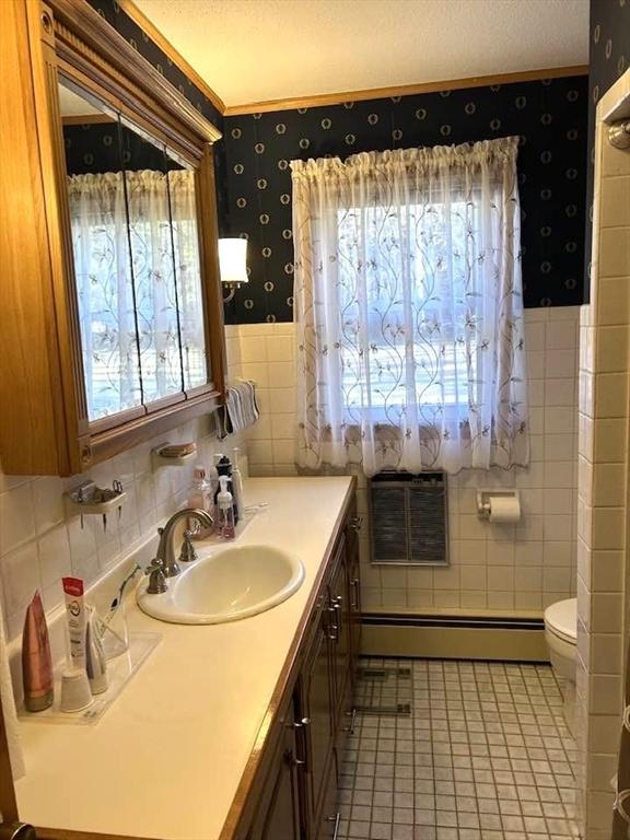 bathroom with vanity, tile patterned floors, toilet, a textured ceiling, and a baseboard radiator