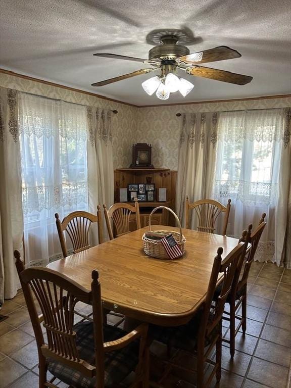 dining room with tile patterned flooring, ceiling fan, and crown molding