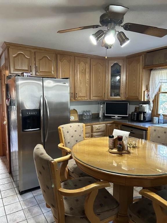 kitchen featuring dishwashing machine, ceiling fan, light tile patterned floors, and stainless steel refrigerator with ice dispenser