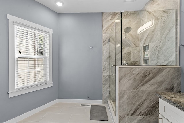 bathroom with tile patterned flooring, an enclosed shower, and vanity