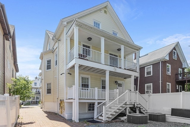 view of front of property with central AC unit, covered porch, and a balcony