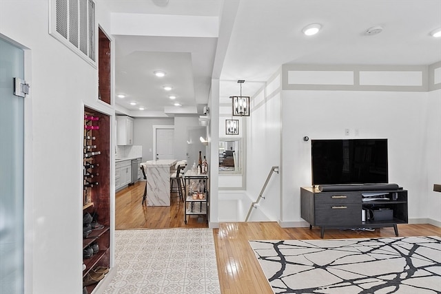 living room featuring an inviting chandelier and light wood-type flooring