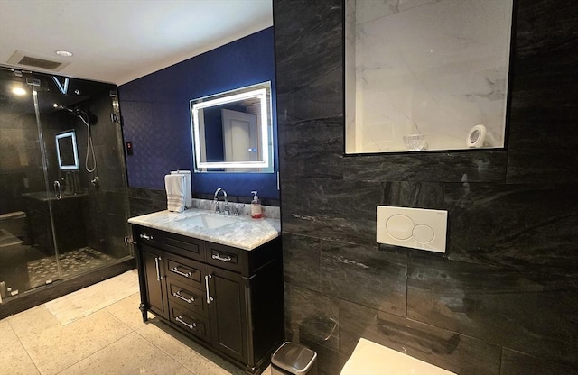 bathroom with a shower with door and vanity