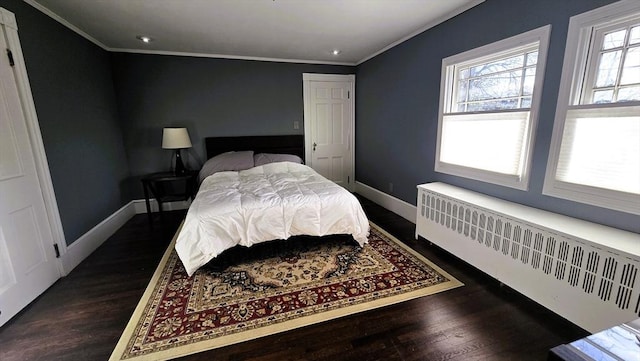 bedroom featuring dark wood-type flooring, ornamental molding, and radiator heating unit