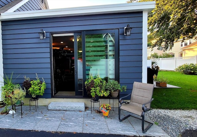 property entrance with a yard and a patio area