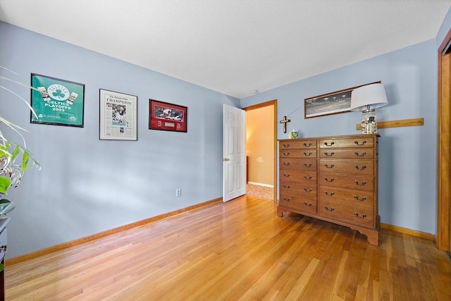 bedroom with wood finished floors and baseboards