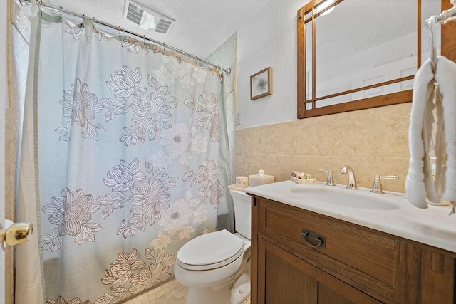 bathroom featuring tile walls, toilet, a textured ceiling, shower / bathtub combination with curtain, and vanity