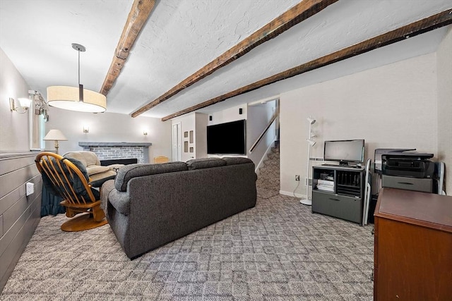 carpeted living room with beamed ceiling and a fireplace