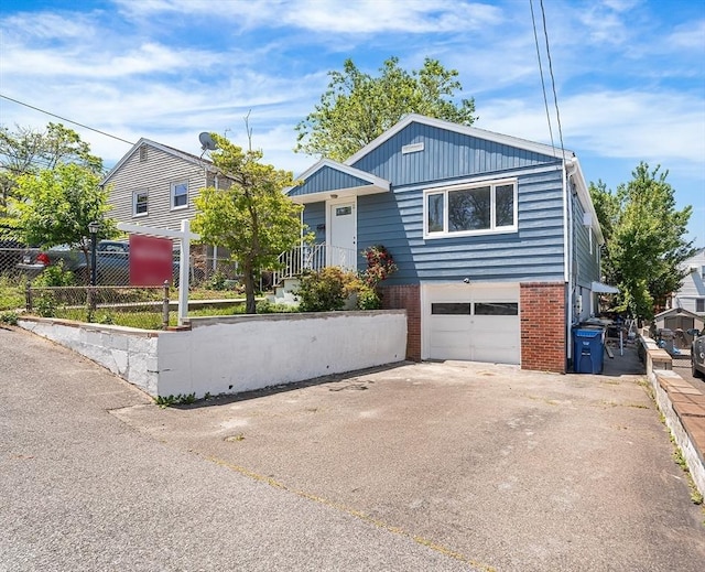 69 Kingman Ave, Revere, MA 02151 - view of front of home featuring an attached garage, brick siding, and concrete driveway