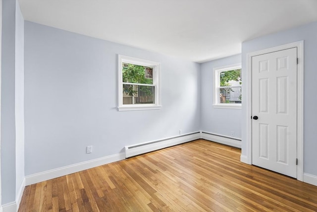 69 Kingman Ave, Revere, MA 02151 - unfurnished room featuring plenty of natural light, wood finished floors, a baseboard heating unit, and a baseboard radiator
