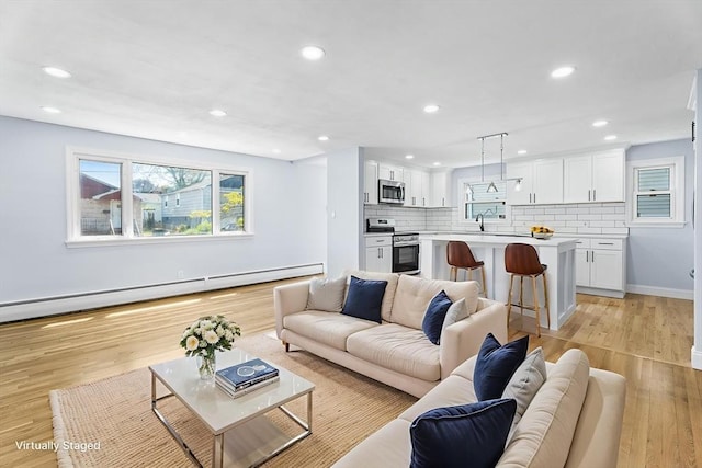 69 Kingman Ave, Revere, MA 02151 - living area with a baseboard heating unit, light wood-style floors, and recessed lighting