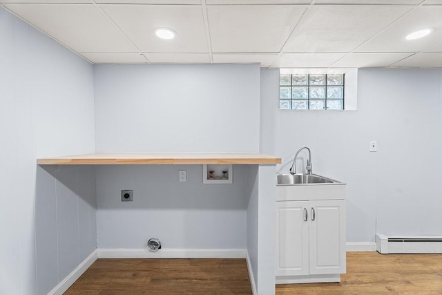 69 Kingman Ave, Revere, MA 02151 - laundry area with a baseboard heating unit, cabinet space, electric dryer hookup, hookup for a washing machine, and wood finished floors