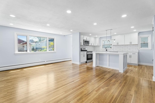 69 Kingman Ave, Revere, MA 02151 - kitchen featuring stainless steel appliances, a baseboard heating unit, recessed lighting, light countertops, and light wood-type flooring