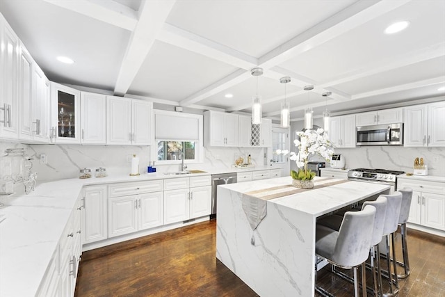 kitchen with dark hardwood / wood-style floors, a center island, white cabinetry, and stainless steel appliances