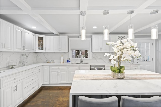 kitchen with beam ceiling, sink, white cabinets, and pendant lighting