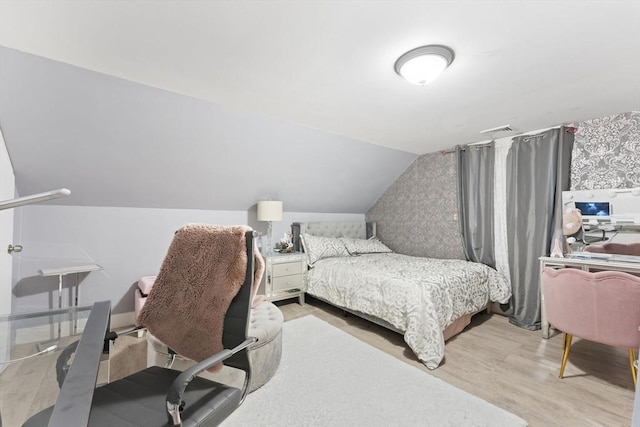 bedroom with hardwood / wood-style floors and lofted ceiling